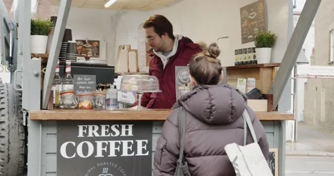 A pleasant smiling young man serving fresh coffee to his female customer Stock Footage 150111496