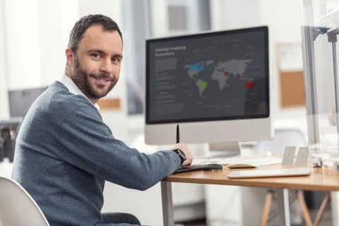 Pleasant young man posing while working on computer Foto stock