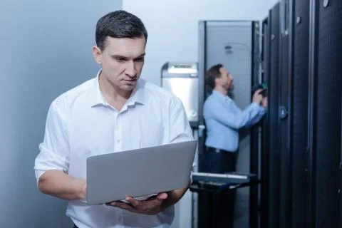 Pleasant young programmer using a laptop Stock Photos