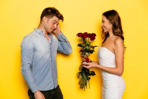 Pleasantly surprised man getting a proposal of marriage from his girlfriend Stock Photos
