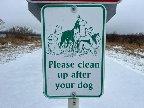 Please clean up after your dog sign in a snowy park Foto stock
