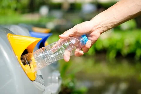 Please dispose of plastic bottle into the tank. A man throw rubbish in the tr Stock Photos