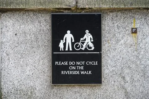 Please Do Not Cycle On The Riverside Walk - sign on wall Foto stock
