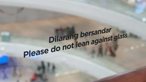 Please Do Not Lean Against Glass Safety Sign at Shopping Mall Stock Footage 345967572