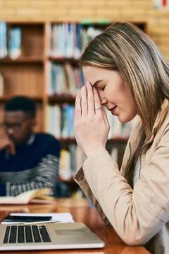 Please dont let me fail this test...a young woman looking stressed while sitting Stock Photos