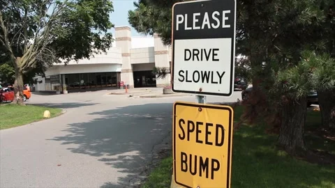 Please drive slowly metal rectangle sign and speed bump sign one on top Stock Footage 247144036