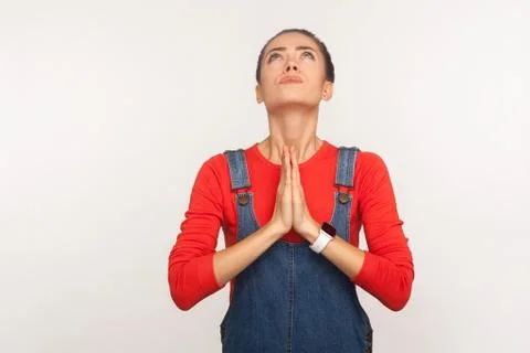 Please god, help! Portrait of imploring worried girl with hair bun in denim o Foto stock