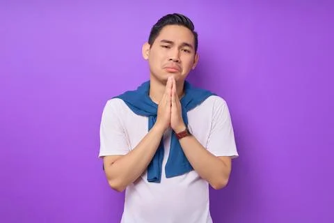 Please help me. young Asian man wearing white t-shirt begging and praying w.. Stock Photos
