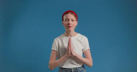 Please, I need. Cute beseeching blonde woman in pullover holding hands in prayer Video stock 150404236