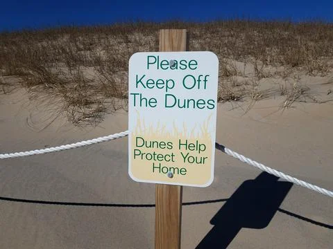 Please keep off the dunes sign with sand and plants Stock Photos