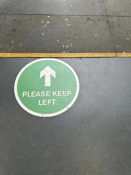 Please keep left green pedestrian sign on asphalt Stock Photos