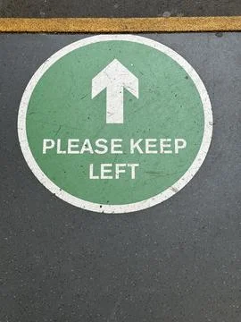 Please keep left pedestrian sign painted on the asphalt Stock Photos