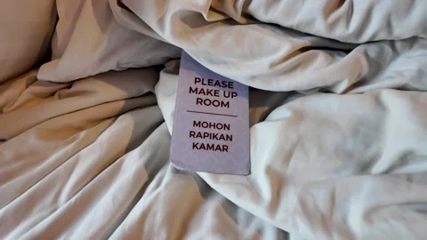 Please Make Up Room sign on messy bed sheets and pillows Stock Footage 345102527