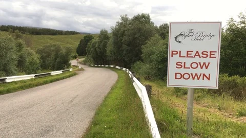 'Please Slow Down' sign, near River Oykel, salmon fishing, Scotland Stock Footage 77192294