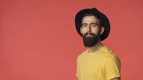 Pleased good-looking bearded middle-eastern man in black hat, yellow t-shirt Stock Footage 115778374