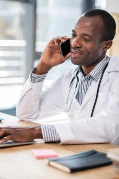 Pleased international practitioner working at computer Stock Photos