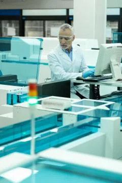 Pleased mature man testing computer in lab Stock Photos
