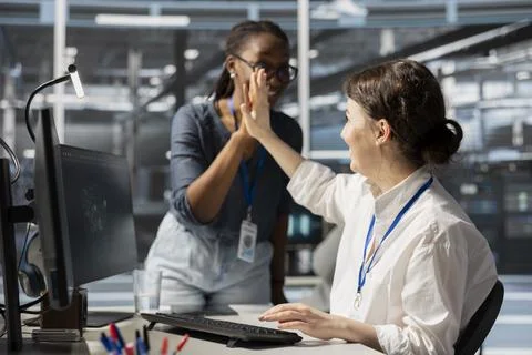 Pleased server farm manager does high five with employee Stockfoto's