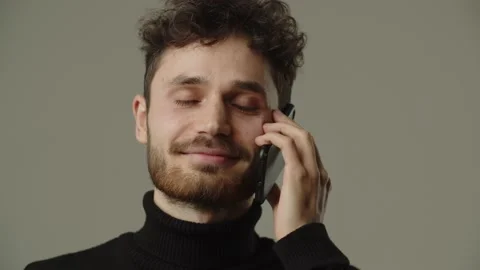 Pleased young man talking on the phone and laughing. Front view of smiling guy Stock Footage 236564053
