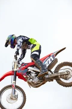 Pleasing the crowd with a little risk-taking. A motocross rider mid-air and on Stock Photos