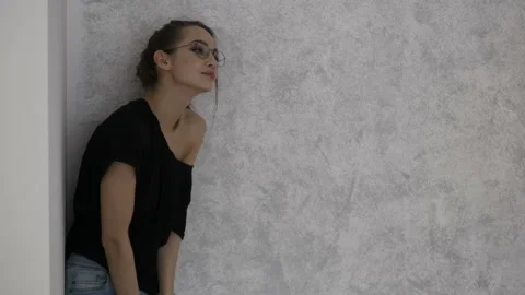 Pleasing girl is standing by the wall Stock Footage 85897924