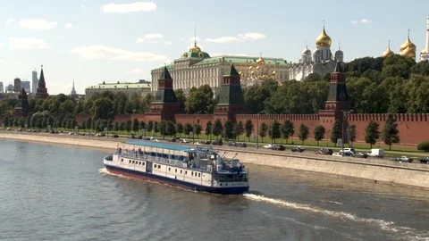 Pleasure boat float past walls of Moscow Kremlin. Car traffic on embankment. Stock Footage 114160791