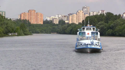 Pleasure boat floats down the river on a summer forest and the city background Stock Footage 39665652