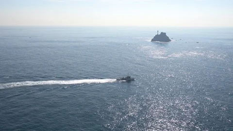 Pleasure boat passing in front of Saengdo island of Busan Taejongdae Stock Footage 101004107