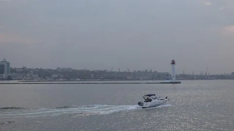 Pleasure boat returns to the port near lighthouse in fog Stock Footage