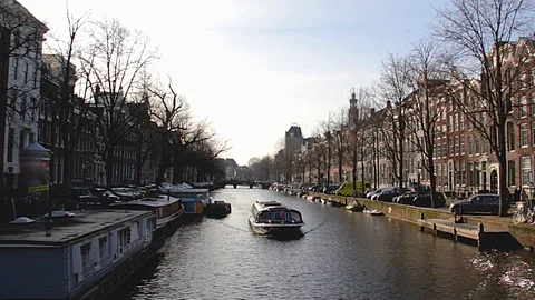 Pleasure boats sail morning in the canal in Amsterdam Stock Footage