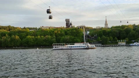 Pleasure craft sails under the cable car across the river 库存影片 195937667