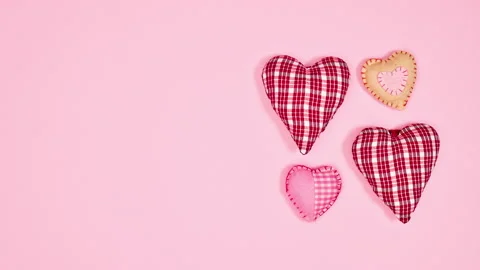 Pleated hearts moving on right side of pastel pink background. Stop motion Stock Footage 230730381