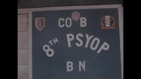 PLEIKU - 1969: Psyop unit sign - Painted battalion board on a clapboard wall Stock-Footage 343934272