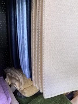 Plentiful textures of fabrics displayed in a home goods store aisle Stock Photos