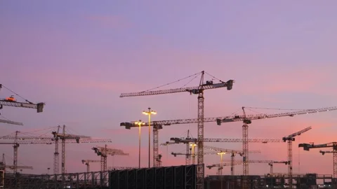 Plenty of cranes working on the mega construction in Saudi Arabia on the sunset Stockbeeldmateriaal 285326427