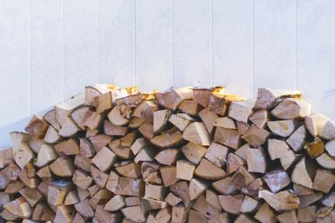 Plenty of firewood stacked next to the wall. Stock Photos