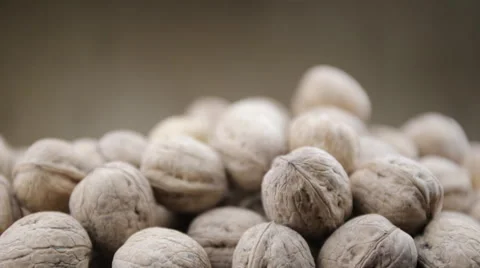 Plenty of walnuts on a table.  Hand choosing one nut. Stock Footage 58480467