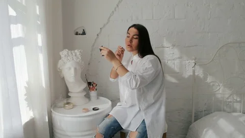 Plesant Girl doing makeup. White Home interior Stock Footage 70512745