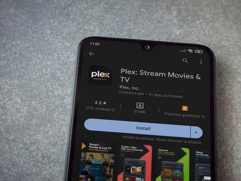 Plex app play store page on smartphone on ceramic stone background Stock Photos