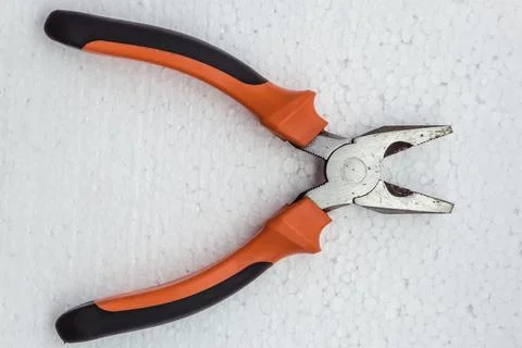 Pliers with a plastic handle on a white background, top view. Stock Photos