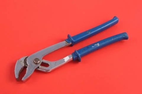 Pliers on a red background. Stock Photos