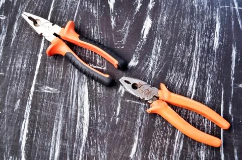 Pliers for repair work lying on the table. Repair tools in the h Stock Photos
