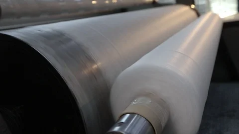 Pliester manufacturing process. Roll-up of non-woven fabric in a factory Stock Footage 117910076