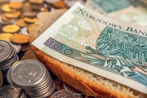 PLN 100 banknote placed on a slice of bread. Difficult financial situation in Stock Photos