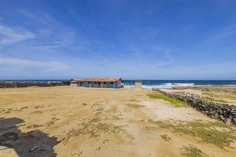 Plot with house surrounded by stone fence in desert on Caribbean sea coast Fotos de archivo
