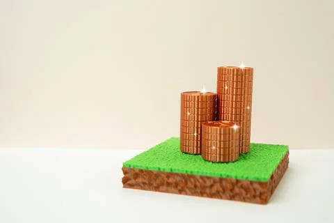 A plot of land and a stack of copper coins. Concept of land investment and pr Stock Photos