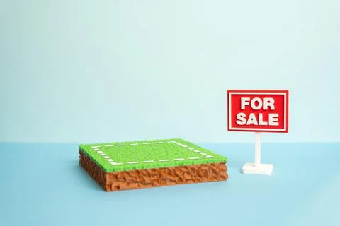 A plot of land is for sale. The plot area has a green lawn and a For Sale s.. Stock Photos