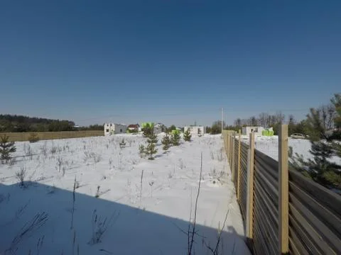 Plot of land in winter. Construction of a private house. Fence on the land in wi Fotos de archivo