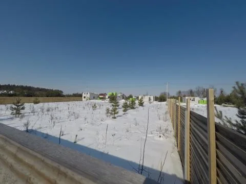 Plot of land in winter. Construction of a private house. Fence on the land in wi Photos