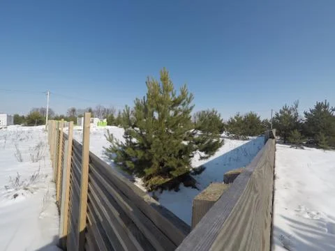 Plot of land in winter. Construction of a private house. Fence on the land in wi Photos